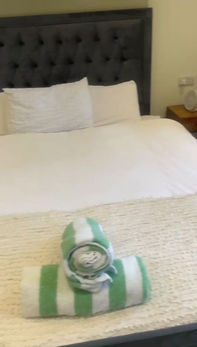 Guest bed made up with rolled towels laid out
